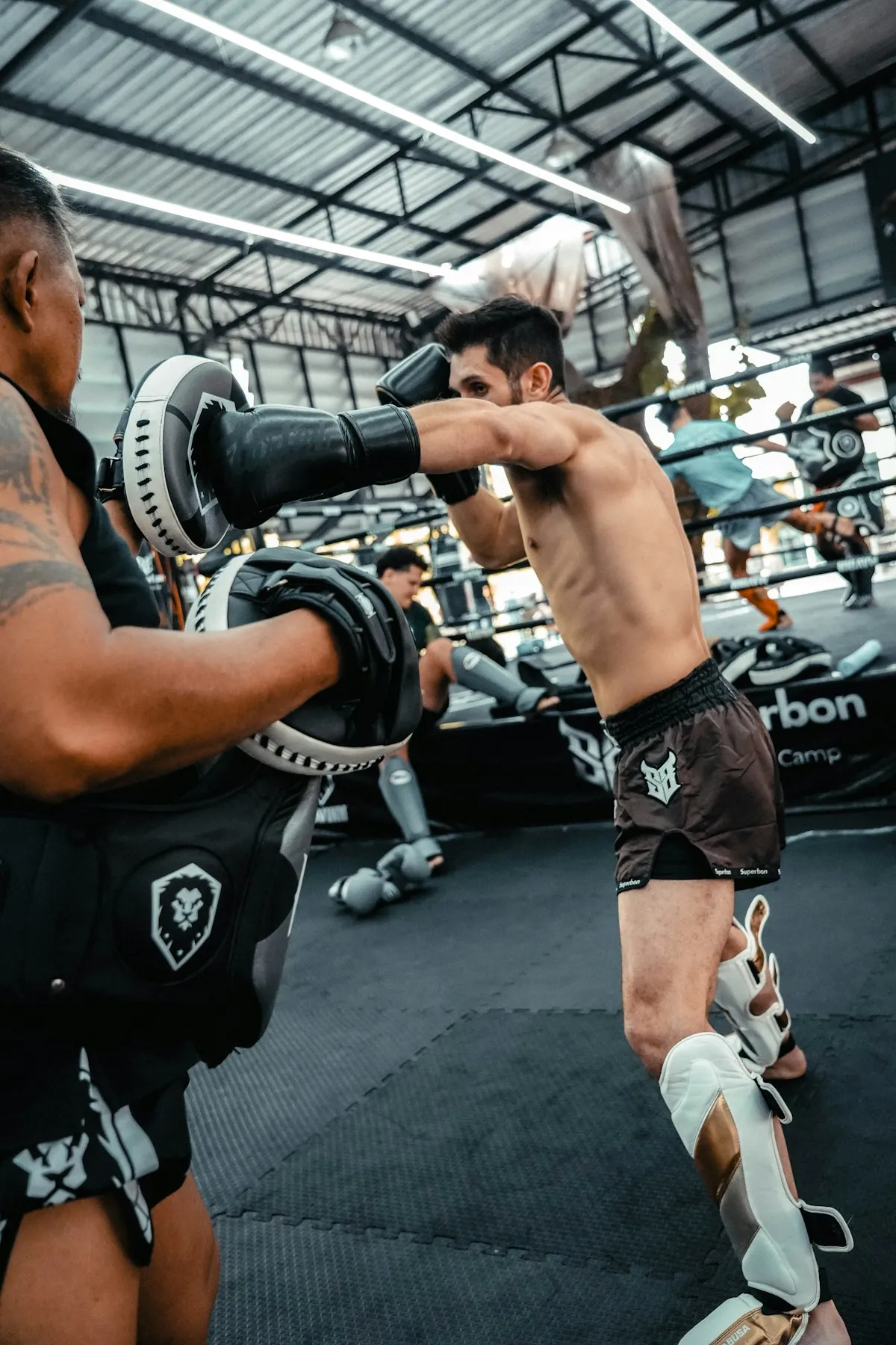 Dos alumnos entrenando Muay Thai en el ring